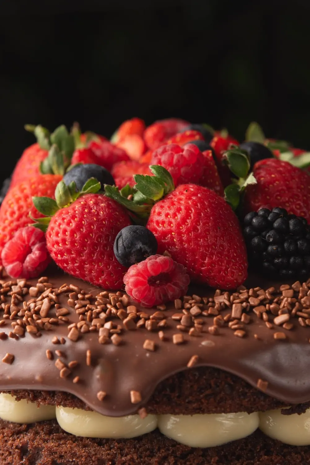 Bolo de chocolate com frutas vermelhas em fundo escuro